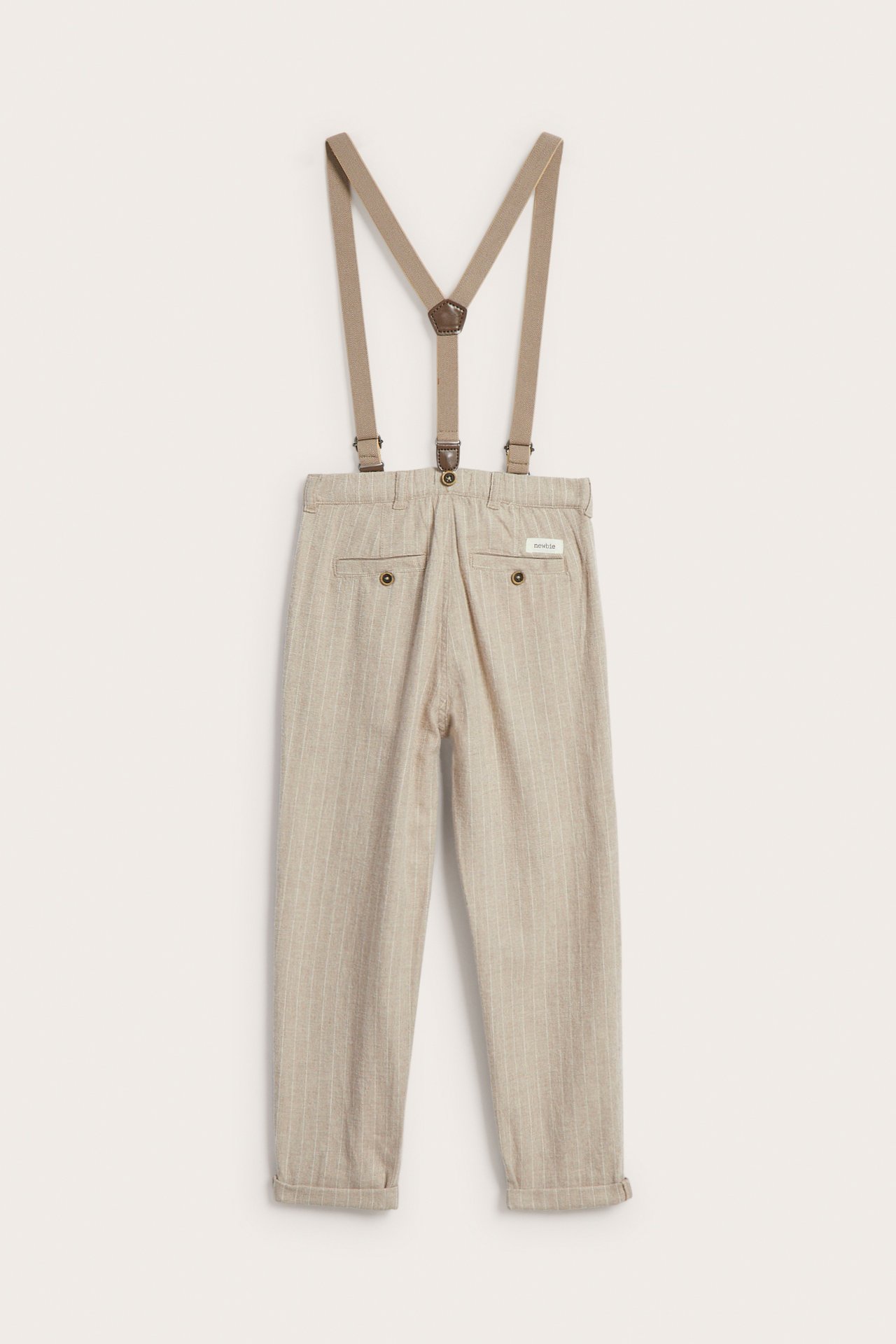 Back view of kid's beige pinstripe trousers with suspenders and cuffed hems.