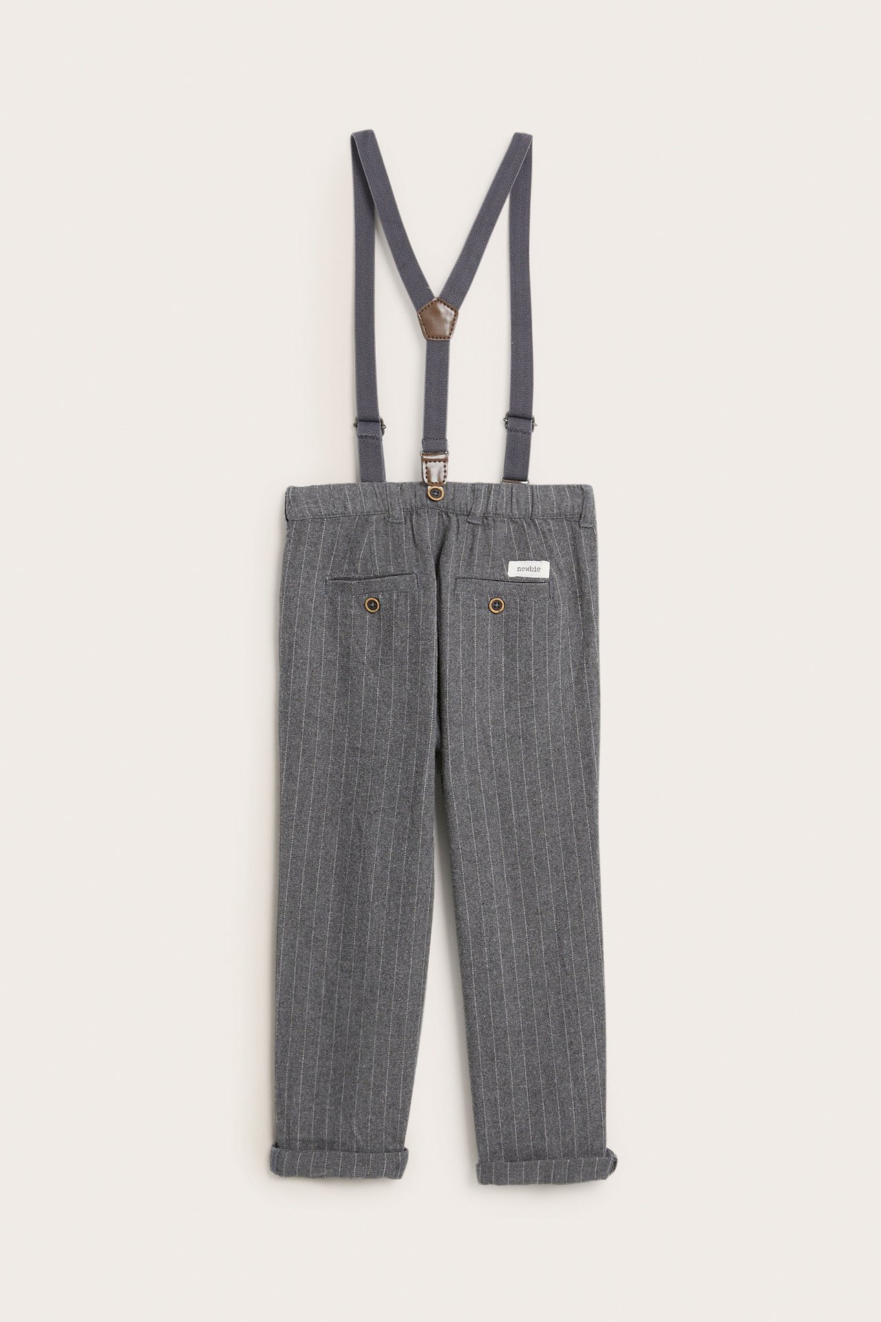 Rückenansicht von Kinderhose, grau gestreift, mit Krempelbein, dunkelgrauen Hosenträgern und Knöpfen.