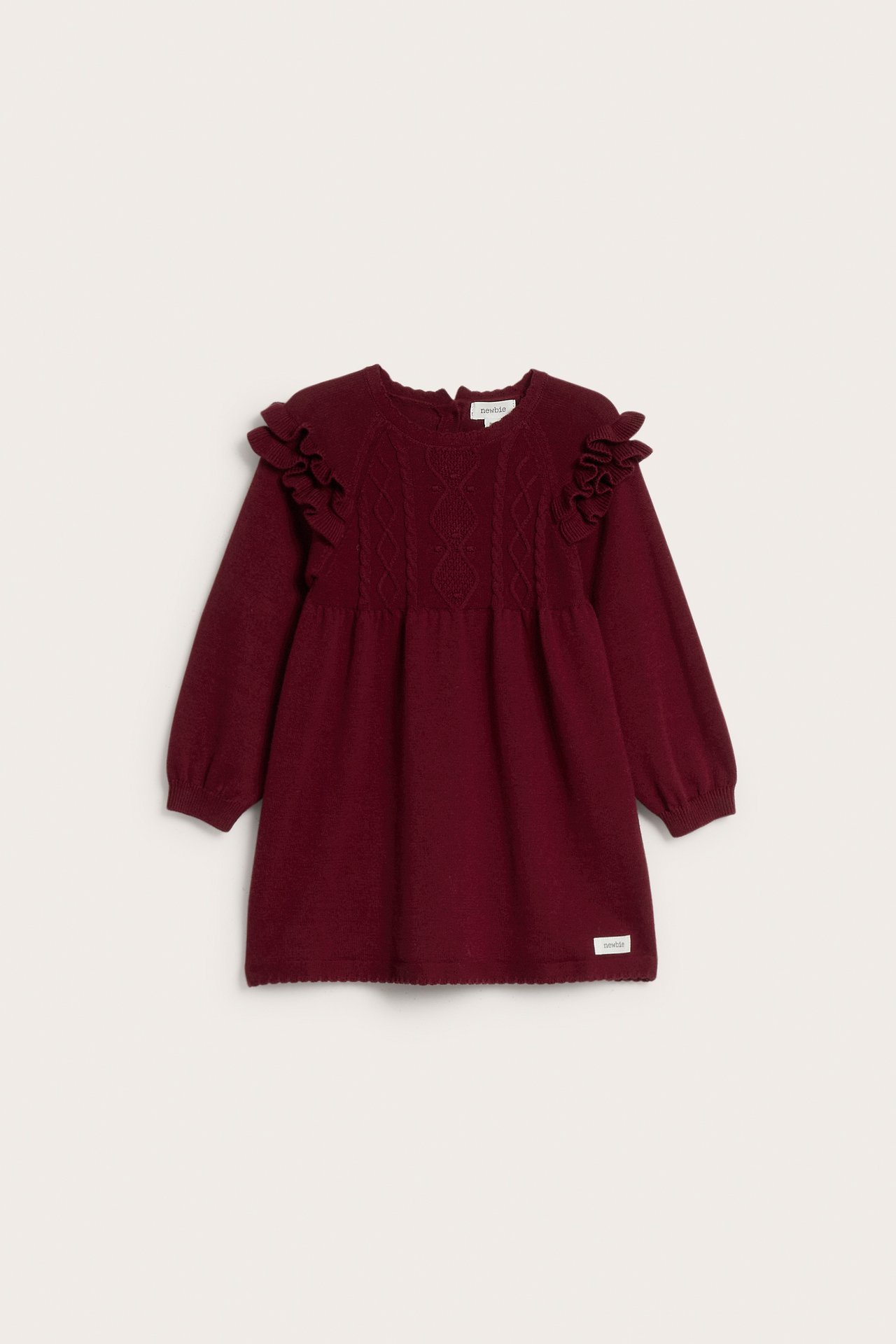 Vorderansicht: Kinder-Strickkleid in Bordeaux mit Zopfmuster am Oberteil und Rüschenschultern.