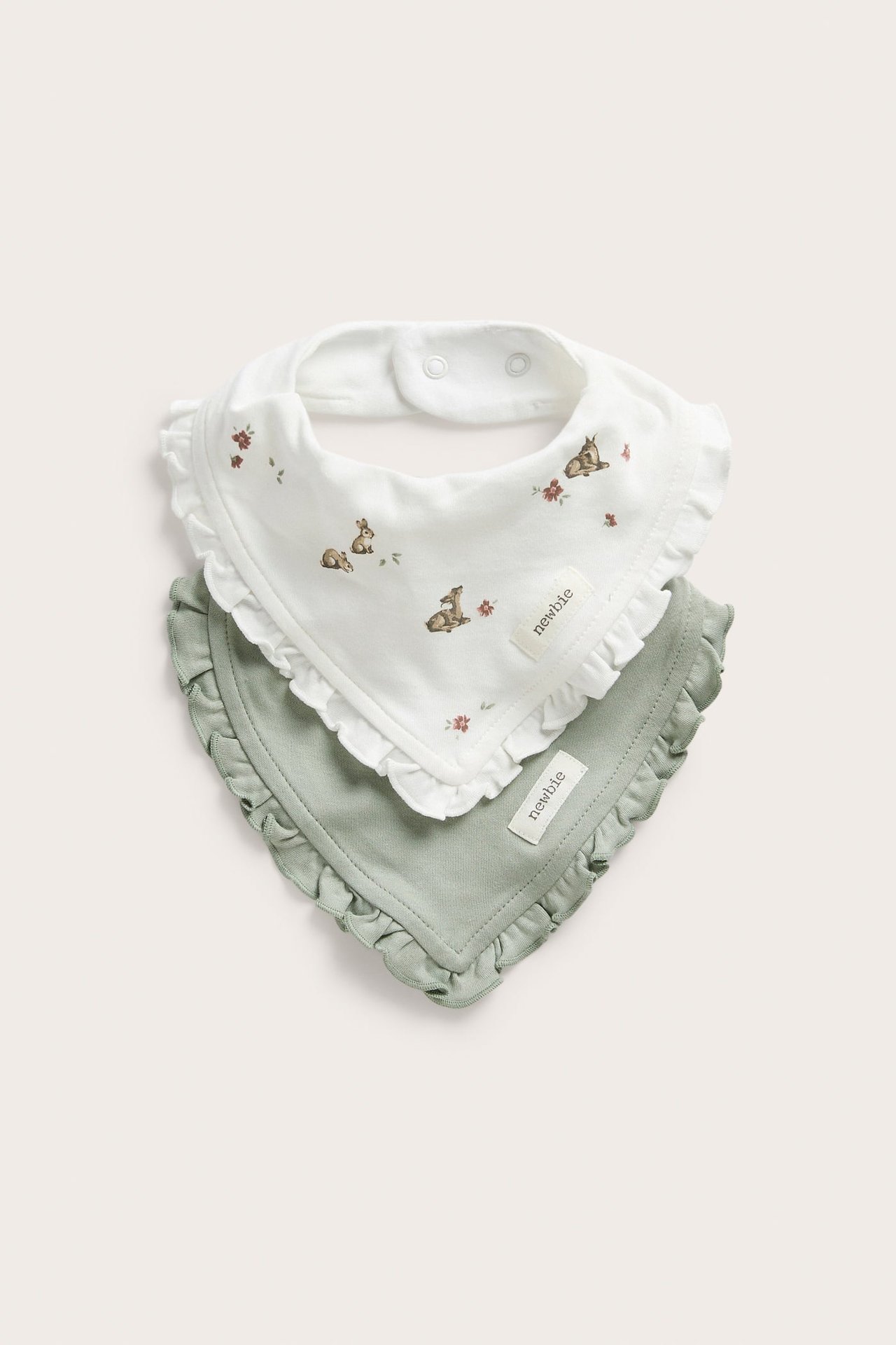 Vorderansicht von zwei Baby-Rüschen-Bandana-Lätzchen, ein weißes mit Tiermuster und ein salbeigrünes.