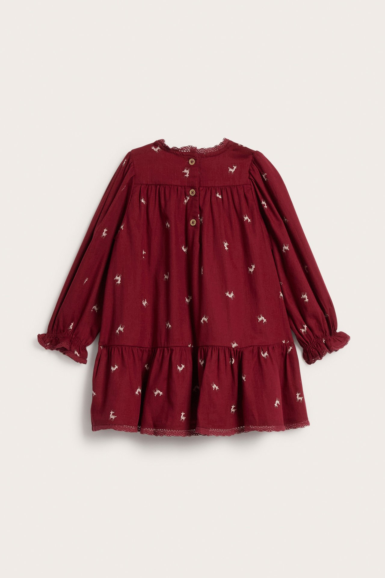 Back view of a kid's maroon long-sleeve tiered dress with white deer print and lace trim.