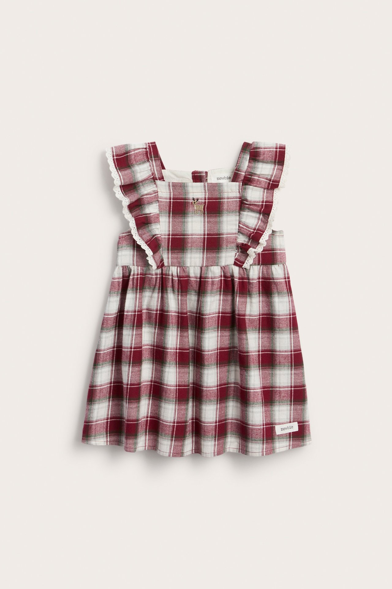 Front view of a baby's red and off-white plaid pinafore dress with lace-trimmed ruffled straps and an embroidered deer.