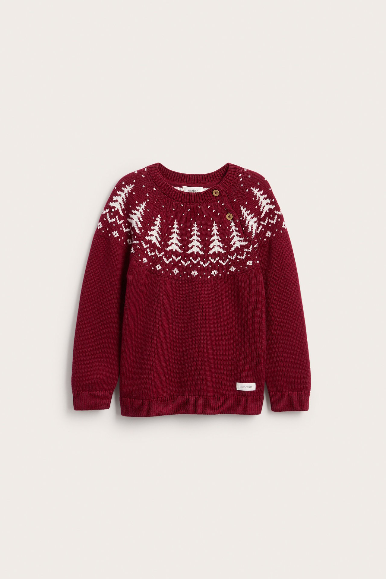 Vorderansicht eines bordeauxroten Kinderstrickpullovers mit weißem Tannenbaum-Muster und zwei Schulterknöpfen.