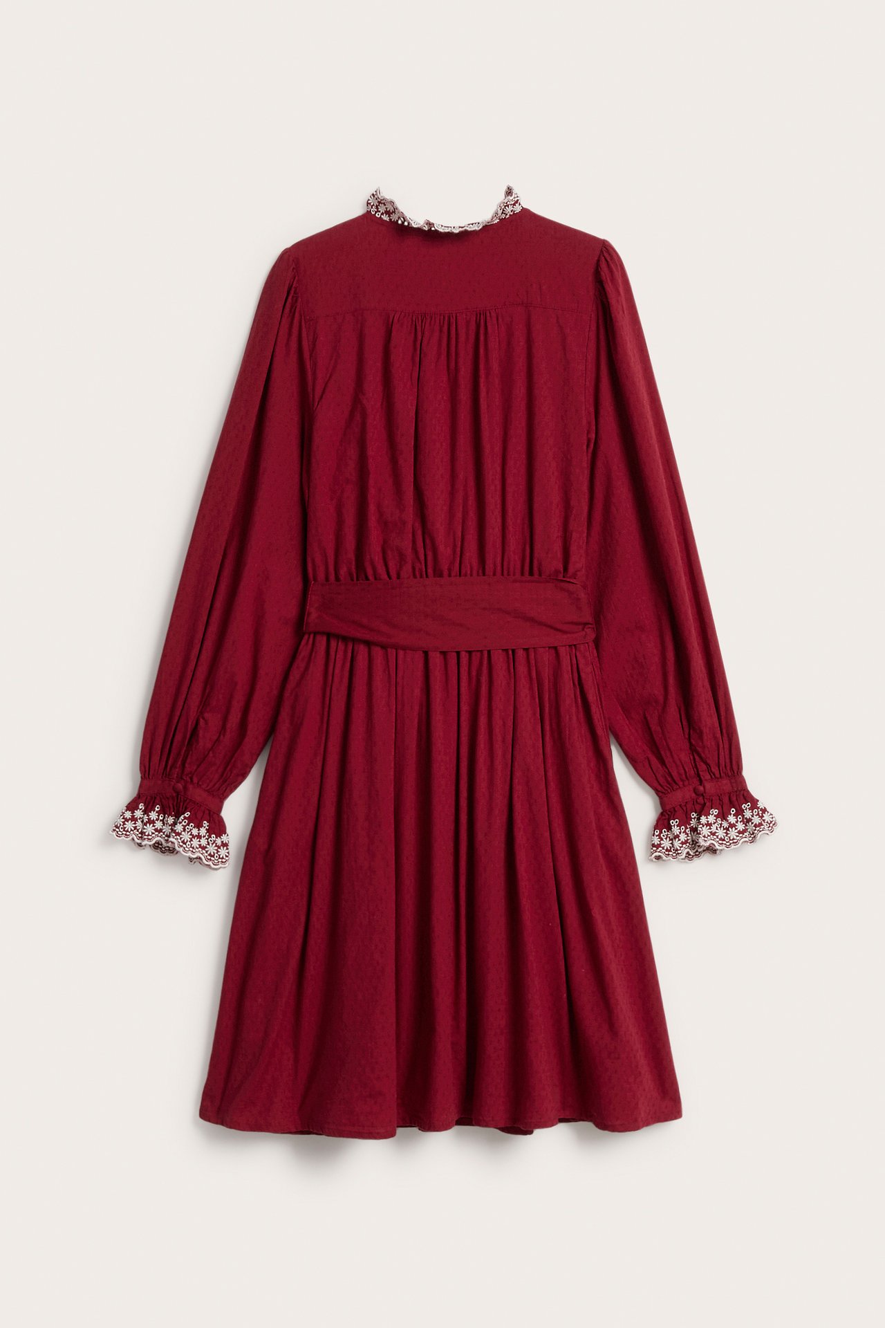 Rückenansicht: rotes gepunktetes Kleid mit besticktem Rüschenkragen, Manschetten, Taillenband.
