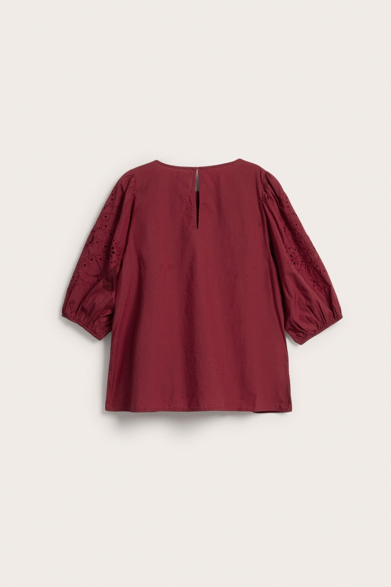 Rückansicht einer weinroten Baumwollbluse mit Puffärmeln und Lochstickerei.