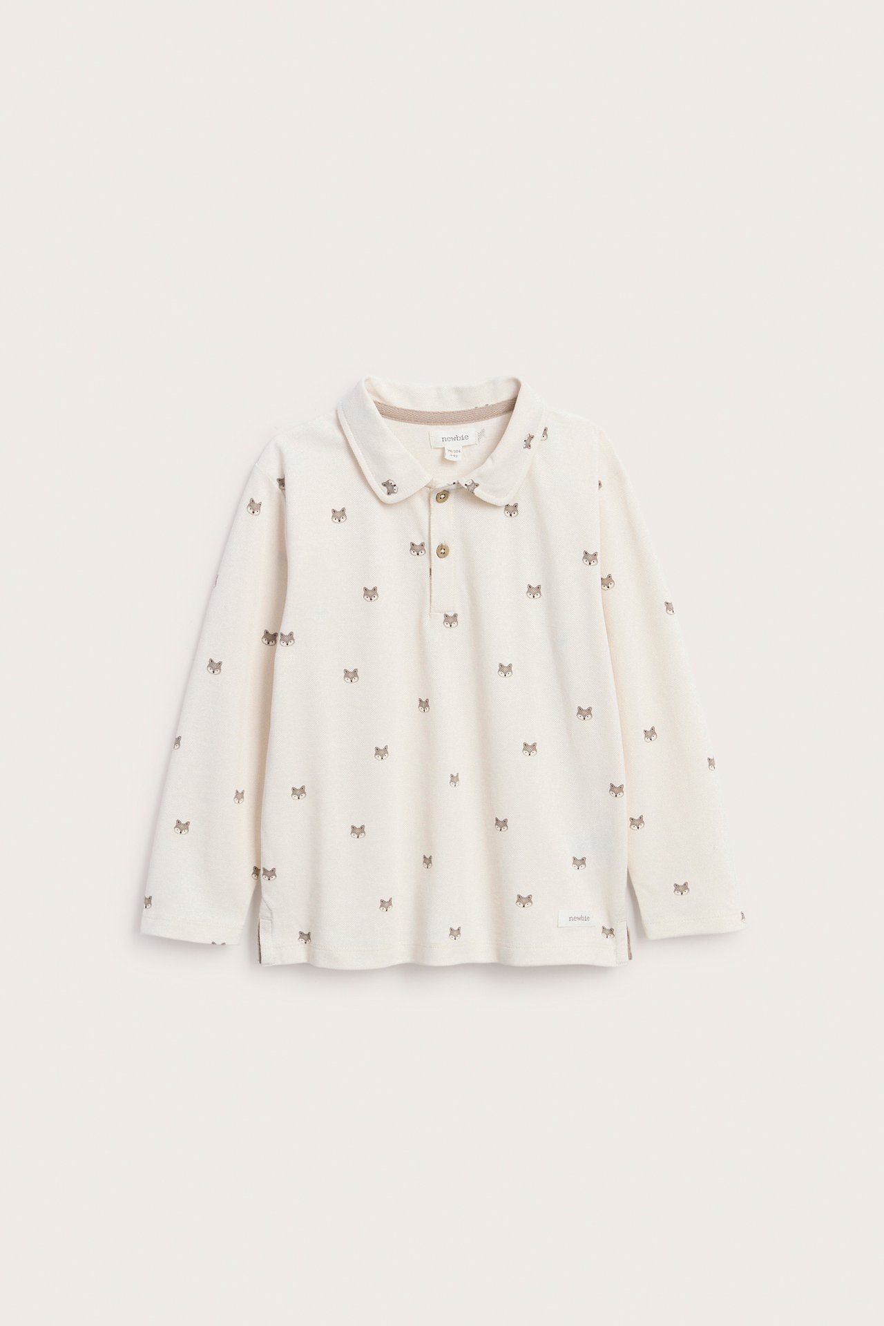 Vorderansicht eines cremefarbenen Kinder-Langarmpoloshirts mit kleinem Fuchsmuster und zwei Knöpfen.