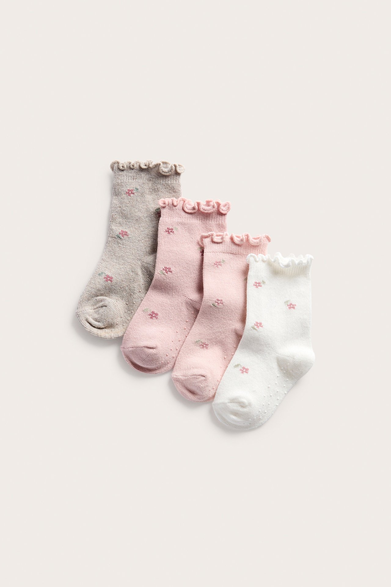 Front view: Four kids' floral socks in light pink, pink, beige, and white with frilled cuffs.