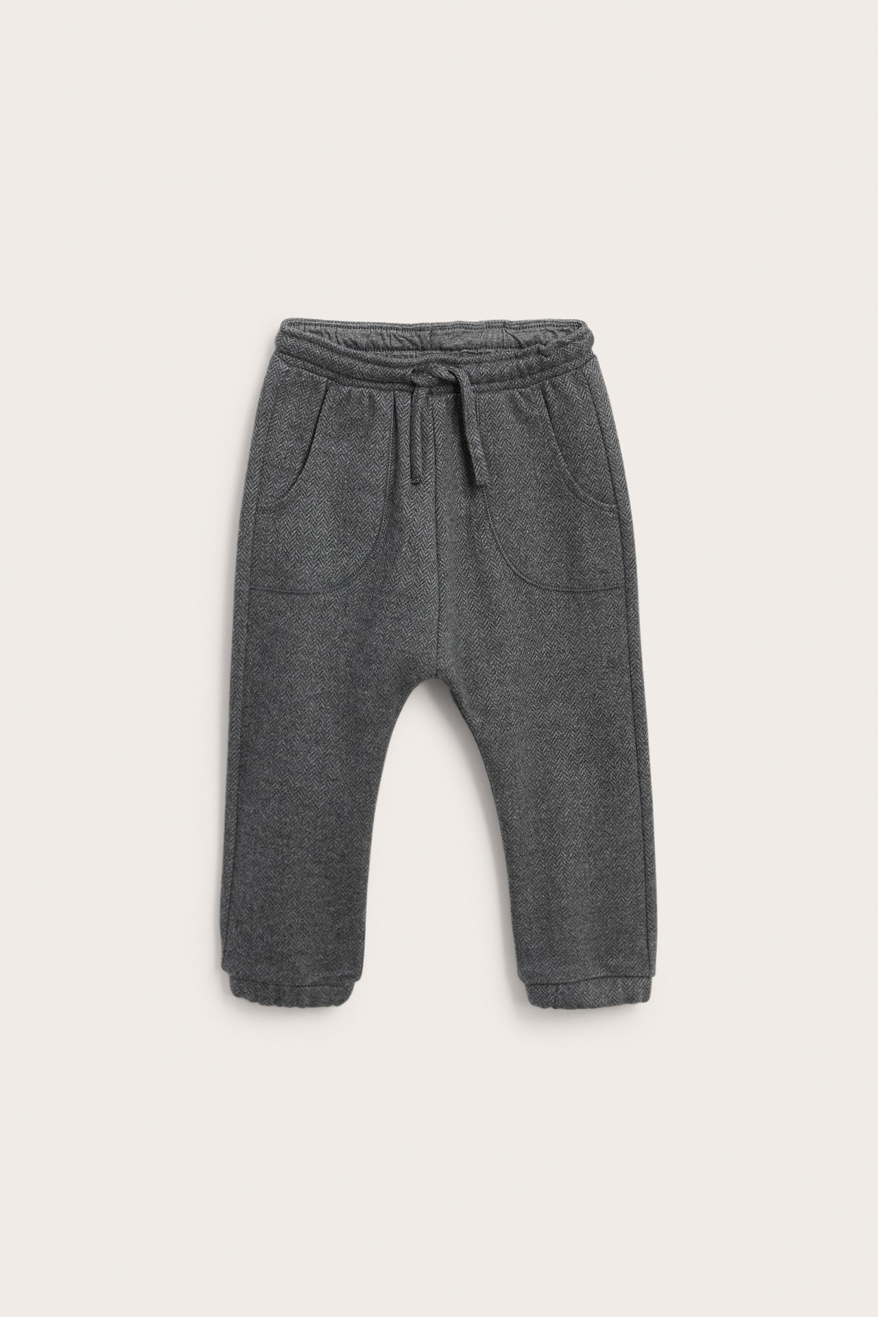 Front view of dark gray herringbone pattern kids' joggers with drawstring waist and two front pockets.