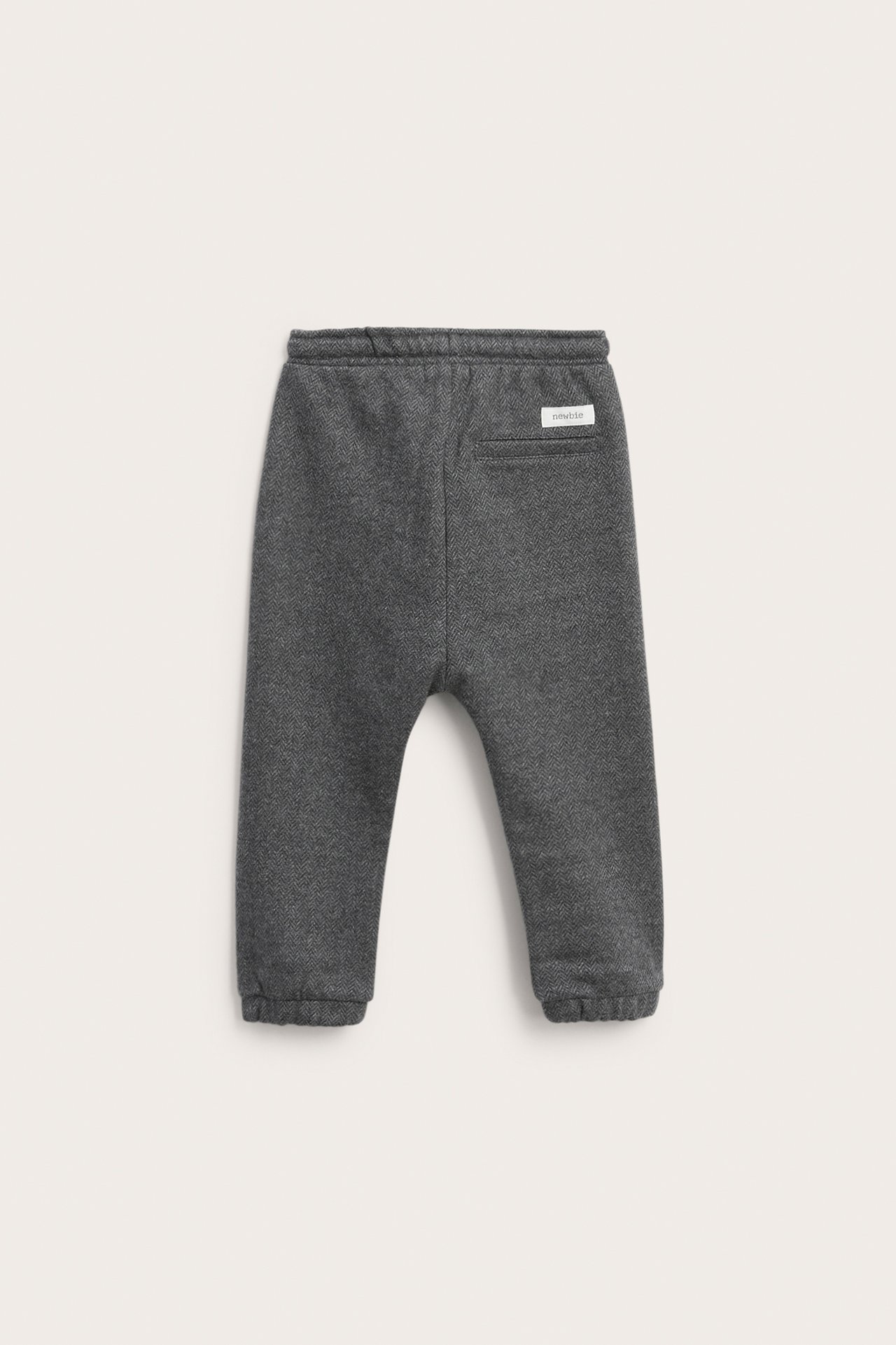 Back view of dark gray herringbone baby sweatpants with elastic waist and cuffs.