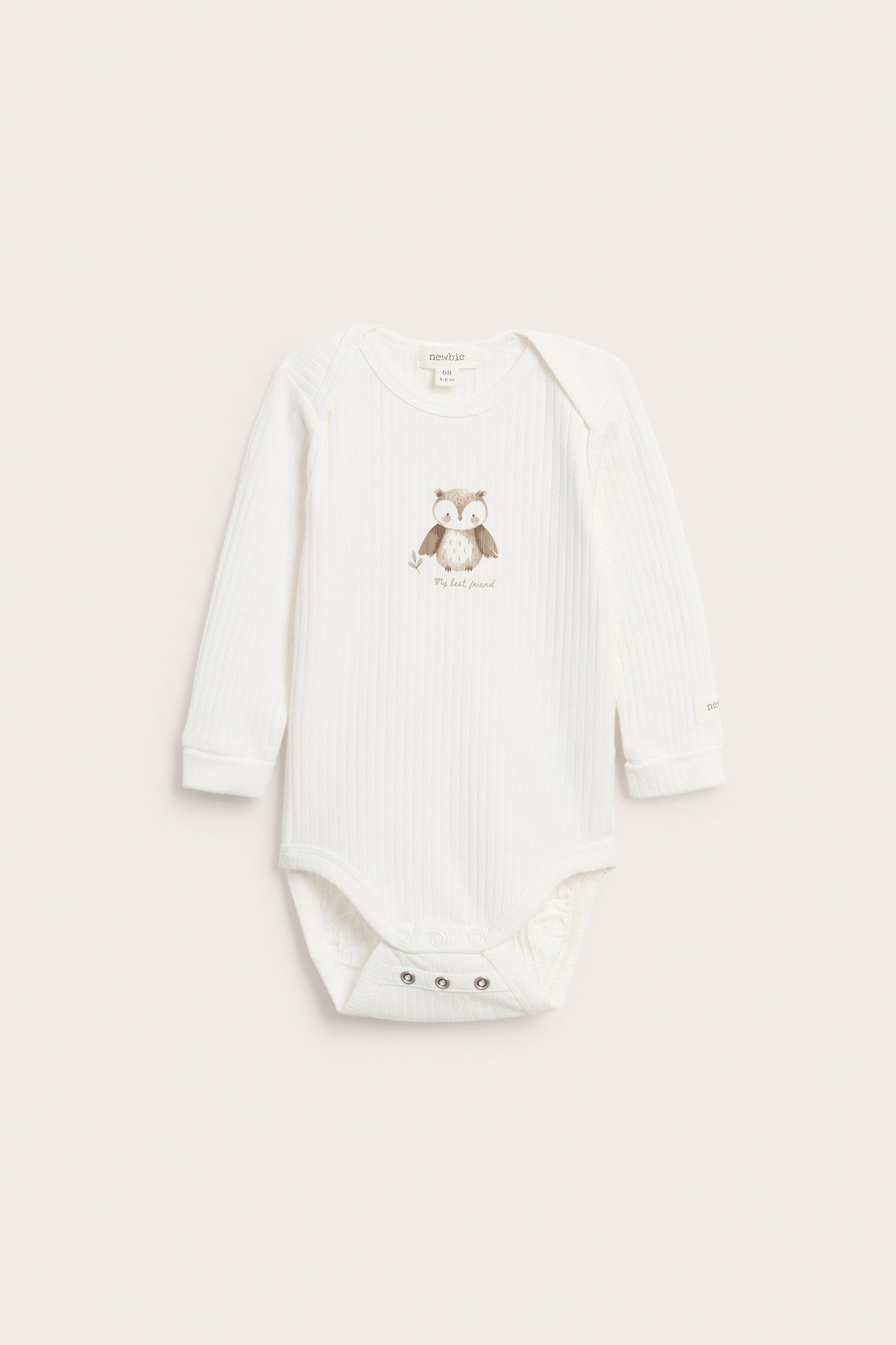 Vorderansicht eines gerippten, langärmeligen Babystramplers in Off-White mit Eulendruck und Druckknöpfen.