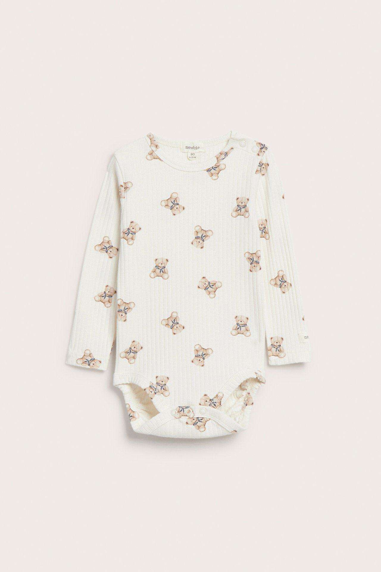 Front view of a ribbed off-white baby bodysuit with allover teddy bear print and snap buttons.