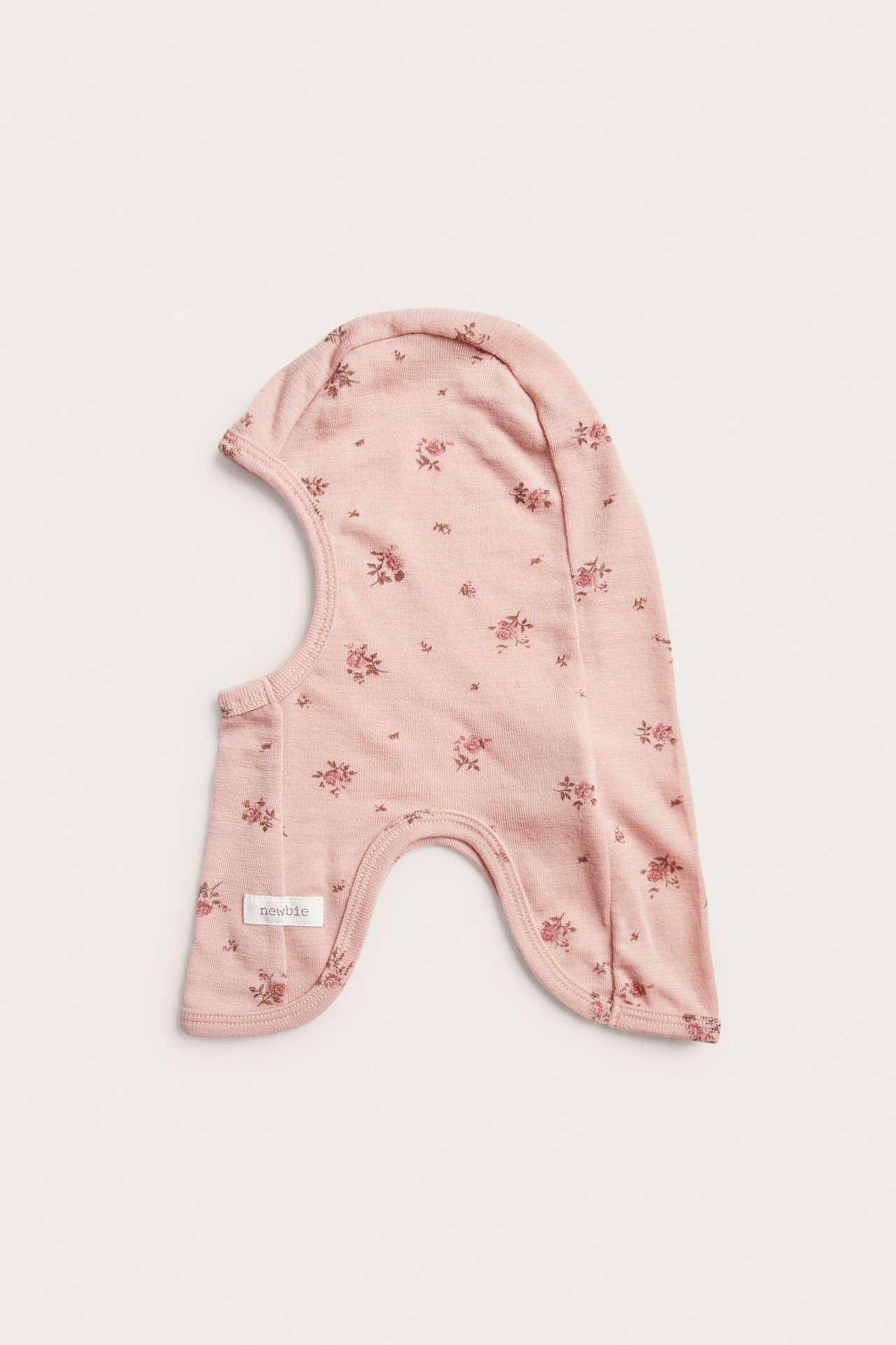 Front view of a pink baby balaclava with a small floral print.
