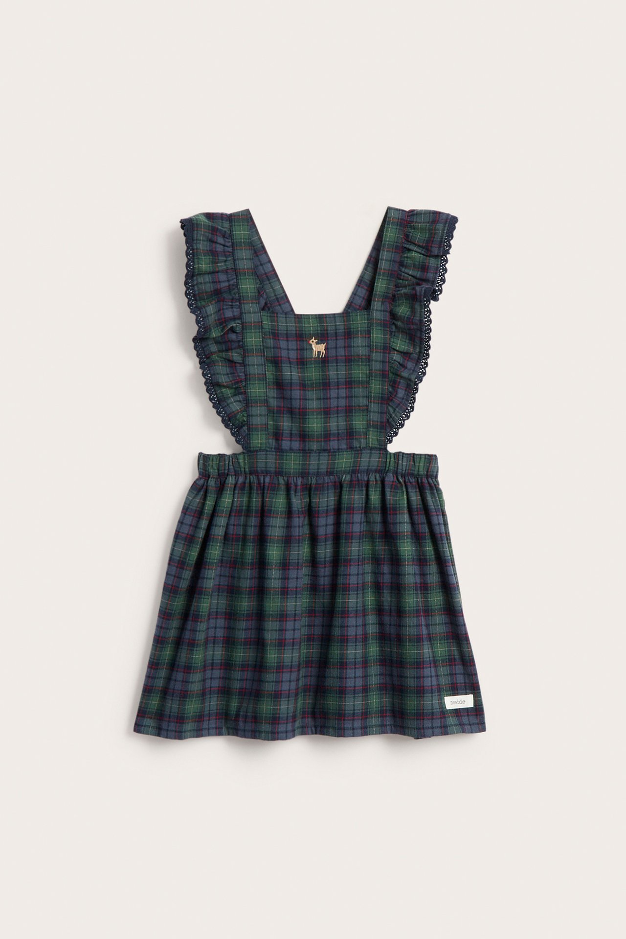 Front view of a kid's green and blue plaid overall dress with ruffled straps and deer embroidery.