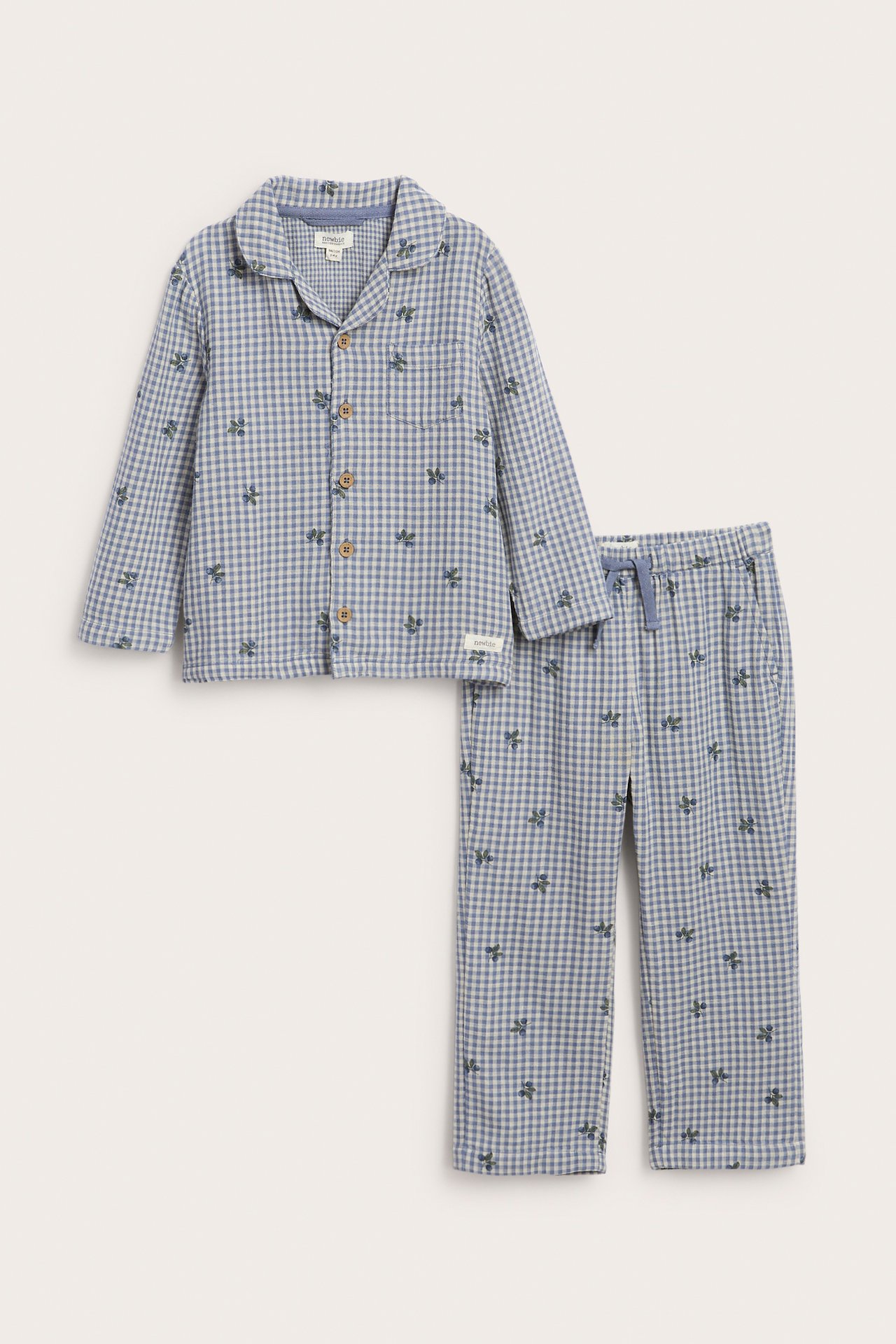 Vorderansicht: Kinder-Pyjama, blau kariert mit kleinem Obstmuster, Hemd mit Kragen und Hose mit Kordelzug.
