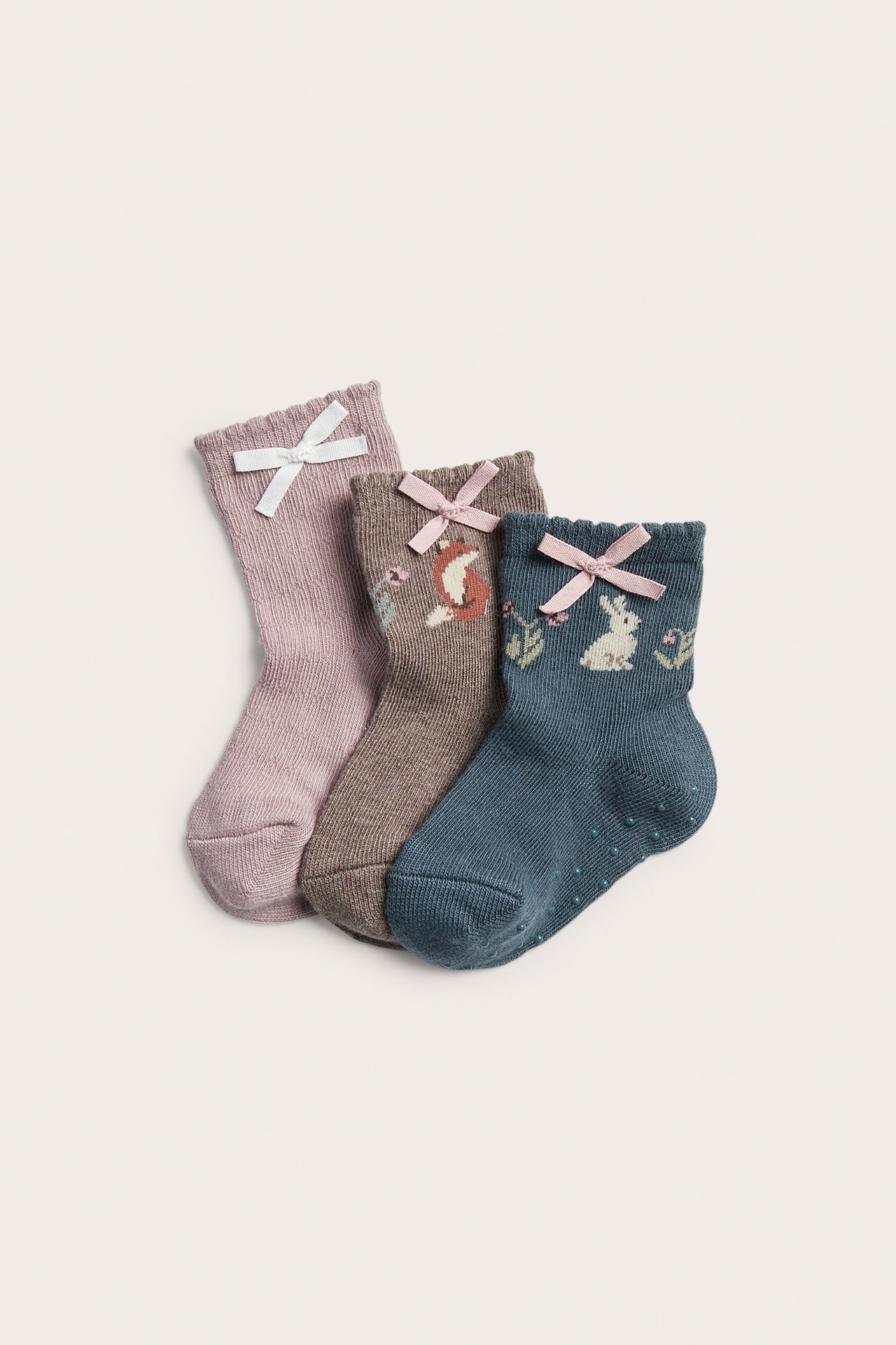 Three pairs of kids' socks with bows: purple, brown with fox, blue with bunny.