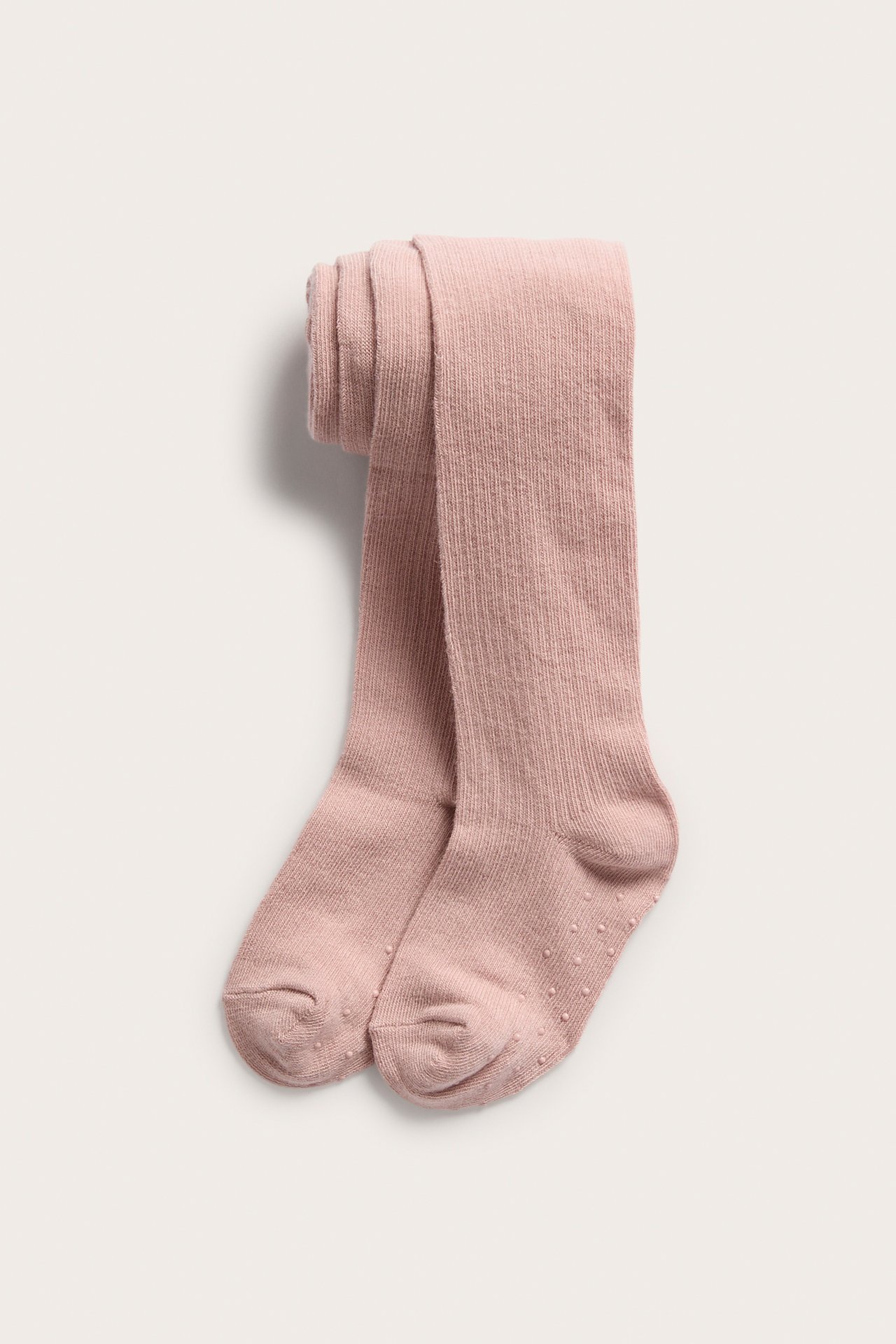 Vorderansicht, gefaltete rosa gerippte Kinderstrumpfhose mit Anti-Rutsch-Sohlen.