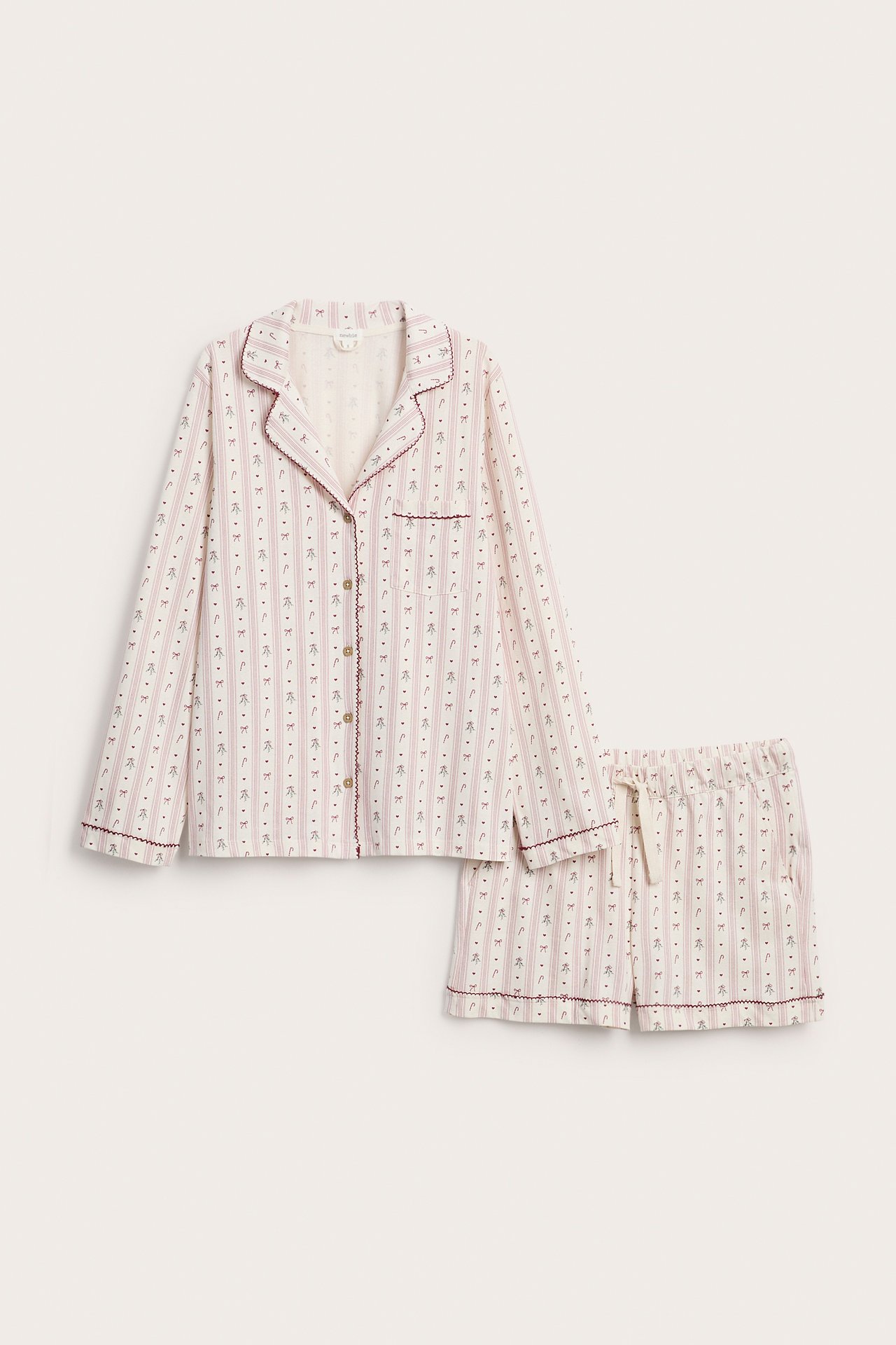 Vorderansicht: Cremefarbenes Pyjama-Set mit Streifen, Paspelierung und Muster, Hemd und Shorts.