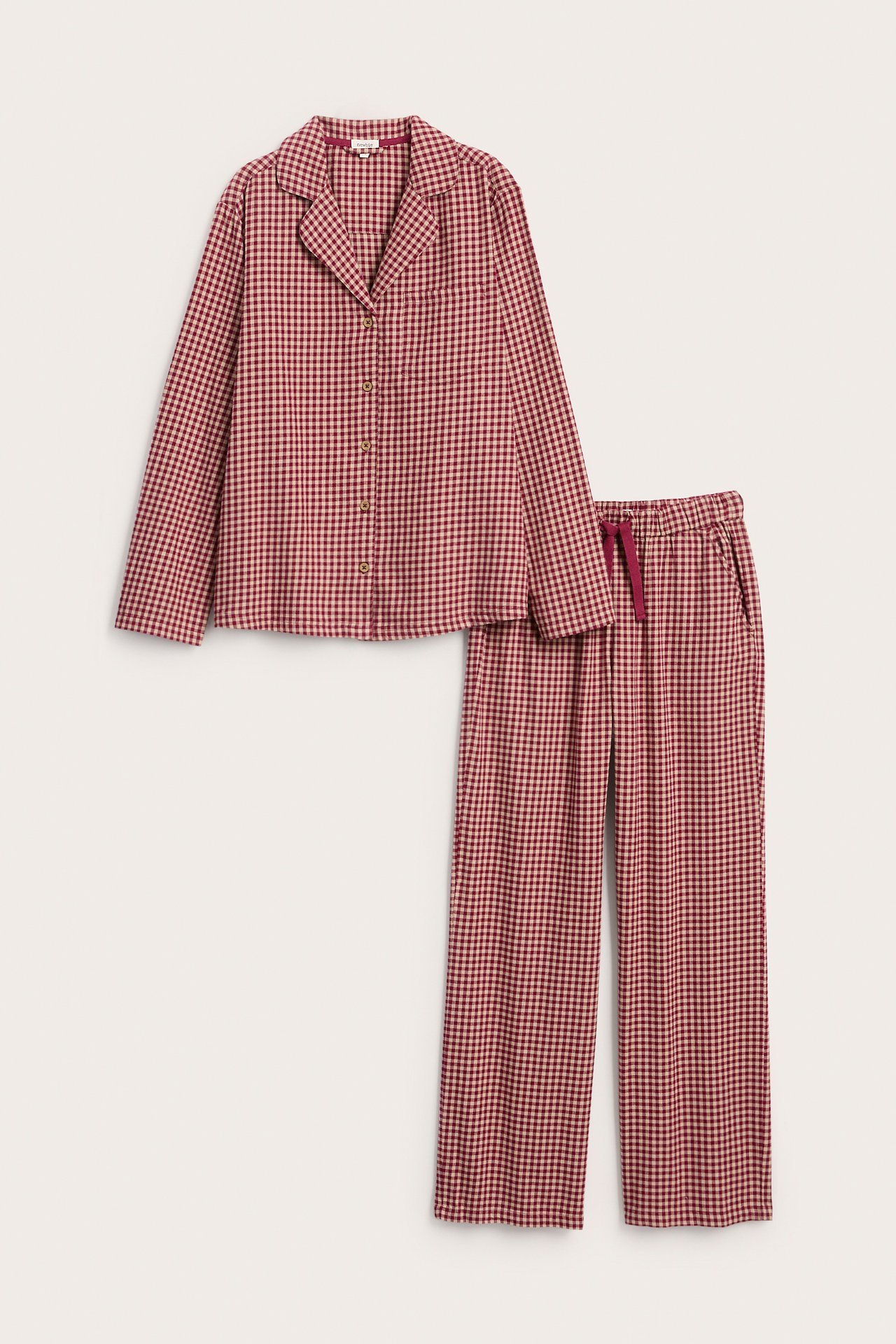 Front view of a red and beige checkered pajama set with a long-sleeved shirt and pants.