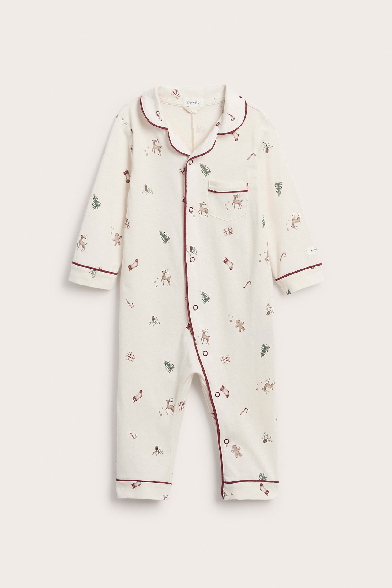 Front view of a baby's off-white Christmas print romper with red piped scalloped collar and snap buttons.
