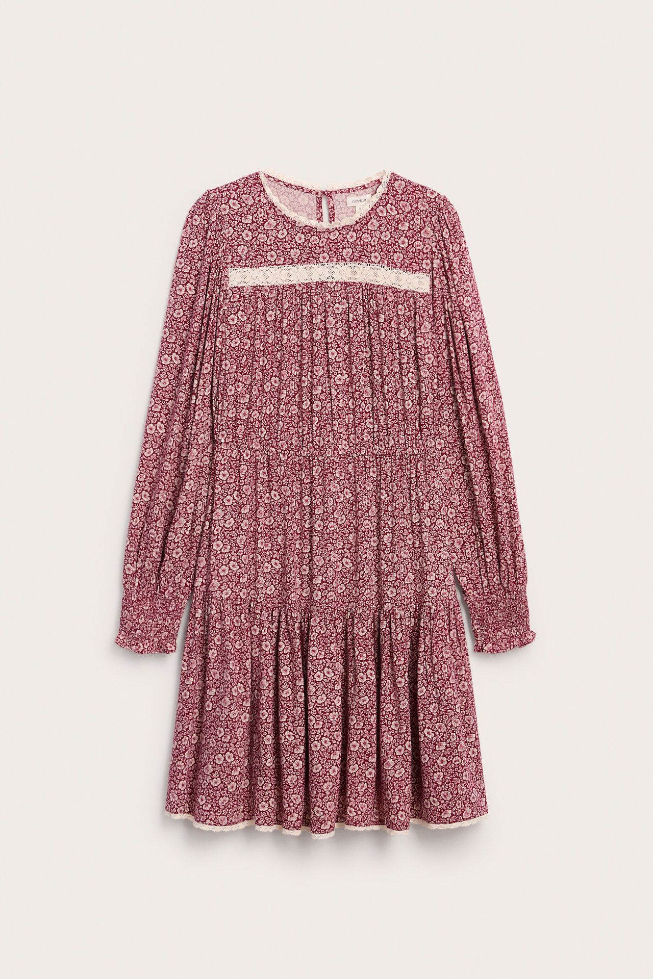Front view of a women's long-sleeved tiered floral dress with lace trim and smocked details.