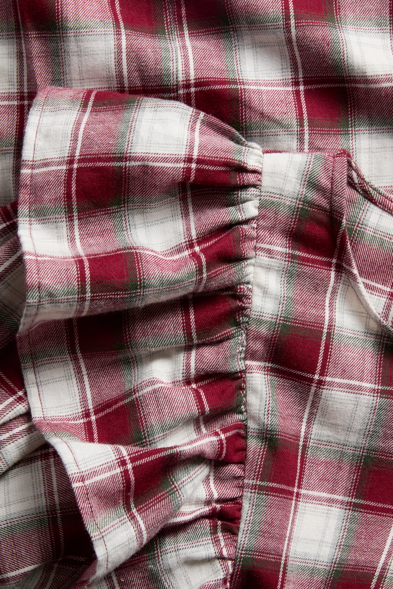 Nahaufnahme eines rot, weiß und grün karierten Rüschen-Flanellkleidungsstücks.