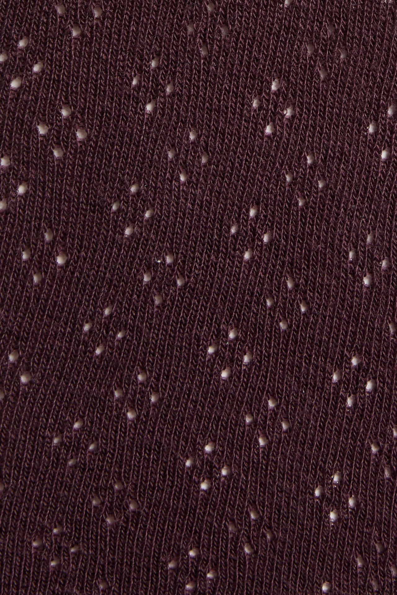 Nahaufnahme von dunkelweinrotem Strickstoff mit kleinen, verstreuten hellen Punkten.