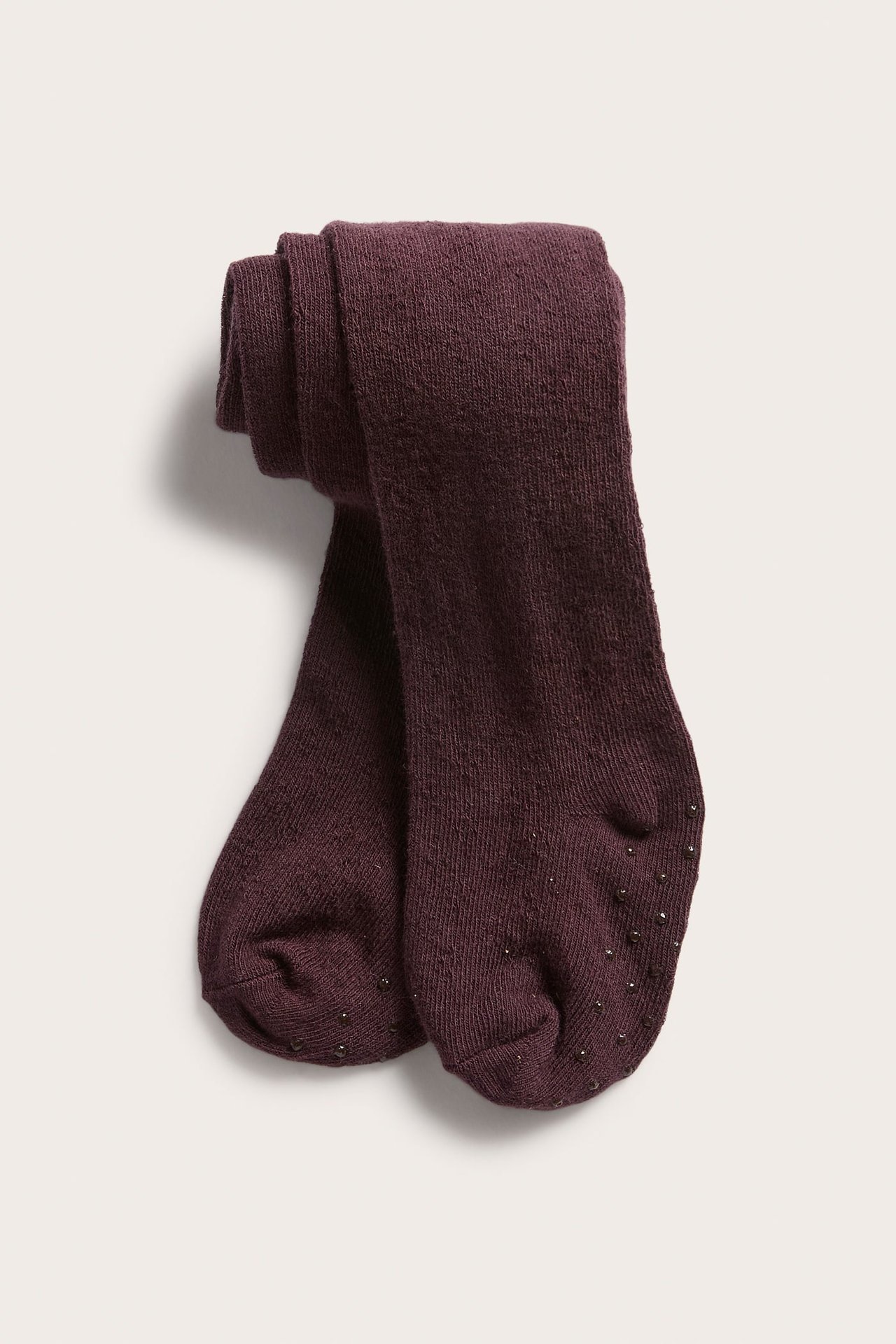 Vorderansicht dunkellila Strickstrumpfhose mit Anti-Rutsch-Noppen an den Sohlen.