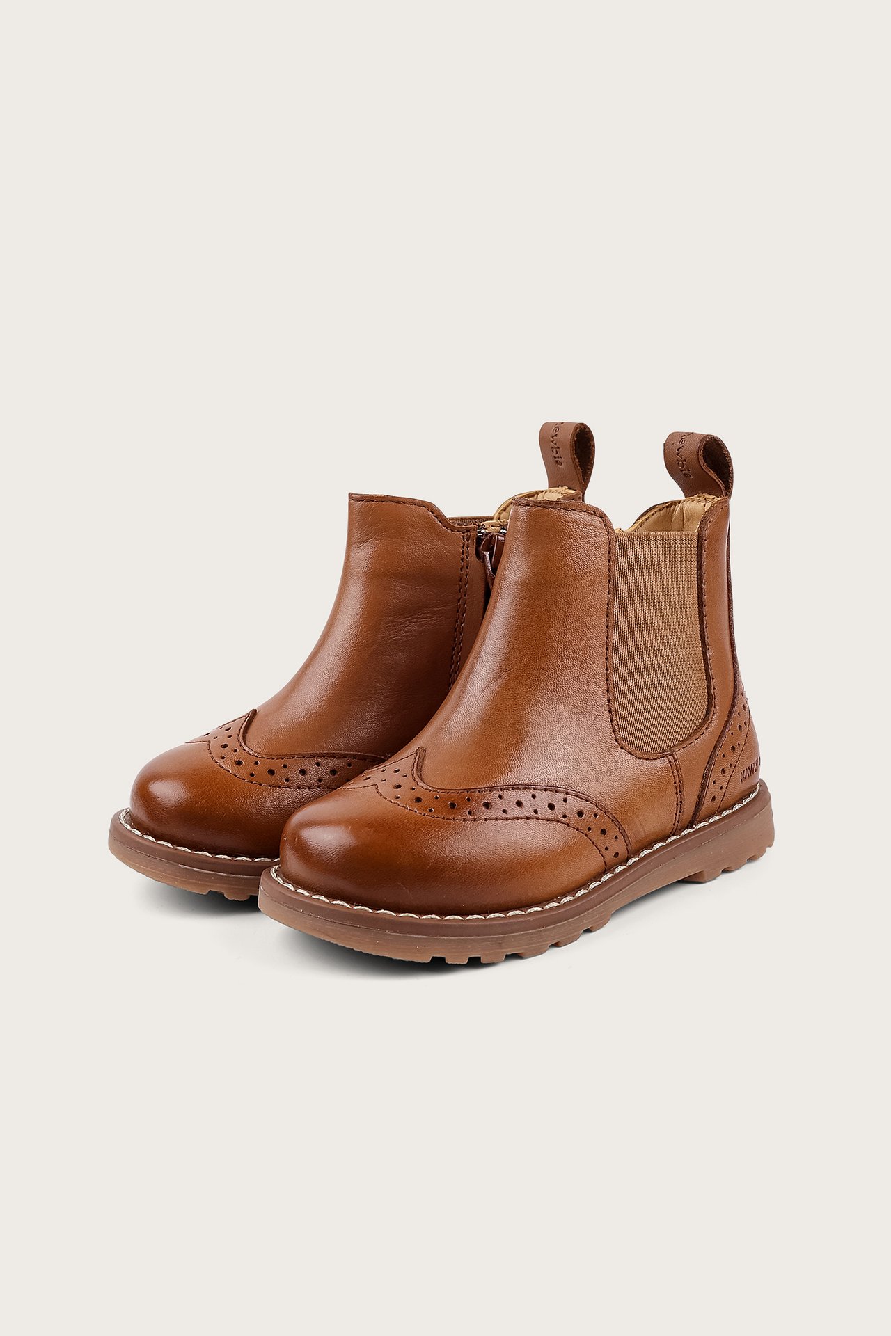 Vorderansicht von zwei braunen Kinder-Chelsea-Stiefeln mit Brogue-Details und elastischen Seitenpanels.