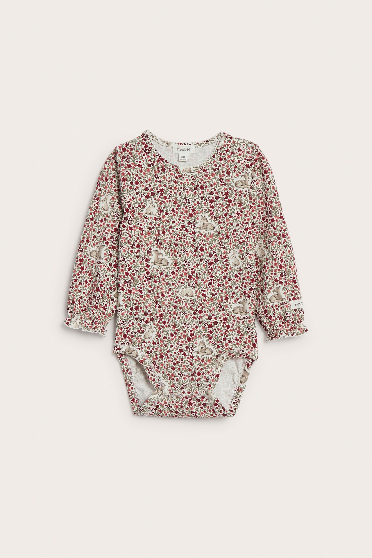 Vorderansicht, Baby-Langarmbody in Cremefarbe mit rotem Blumen-, Hasenmuster und Rüschenbündchen.
