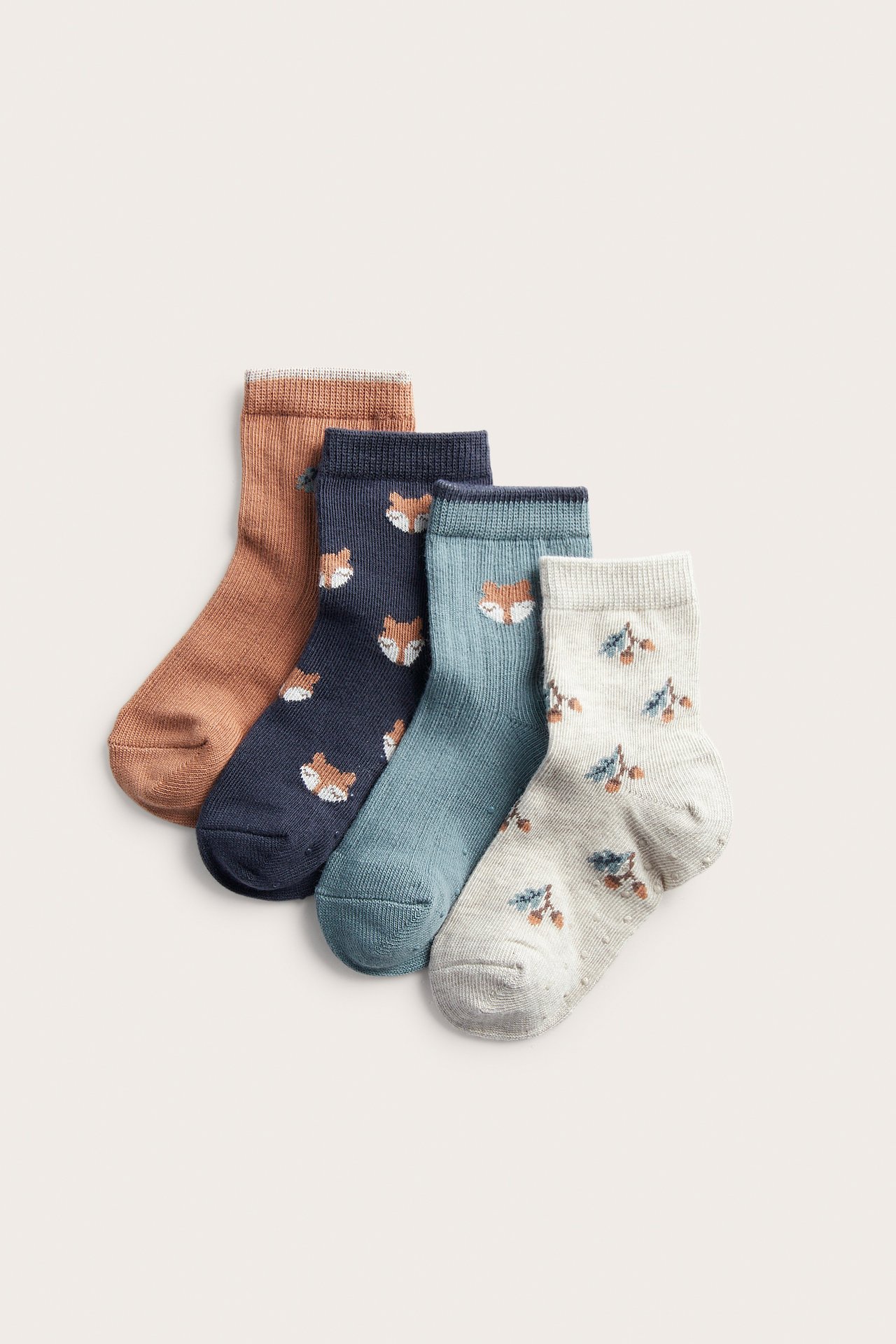 Full view of four pairs of ankle socks: brown, navy with foxes, teal with a fox, and gray with berries.