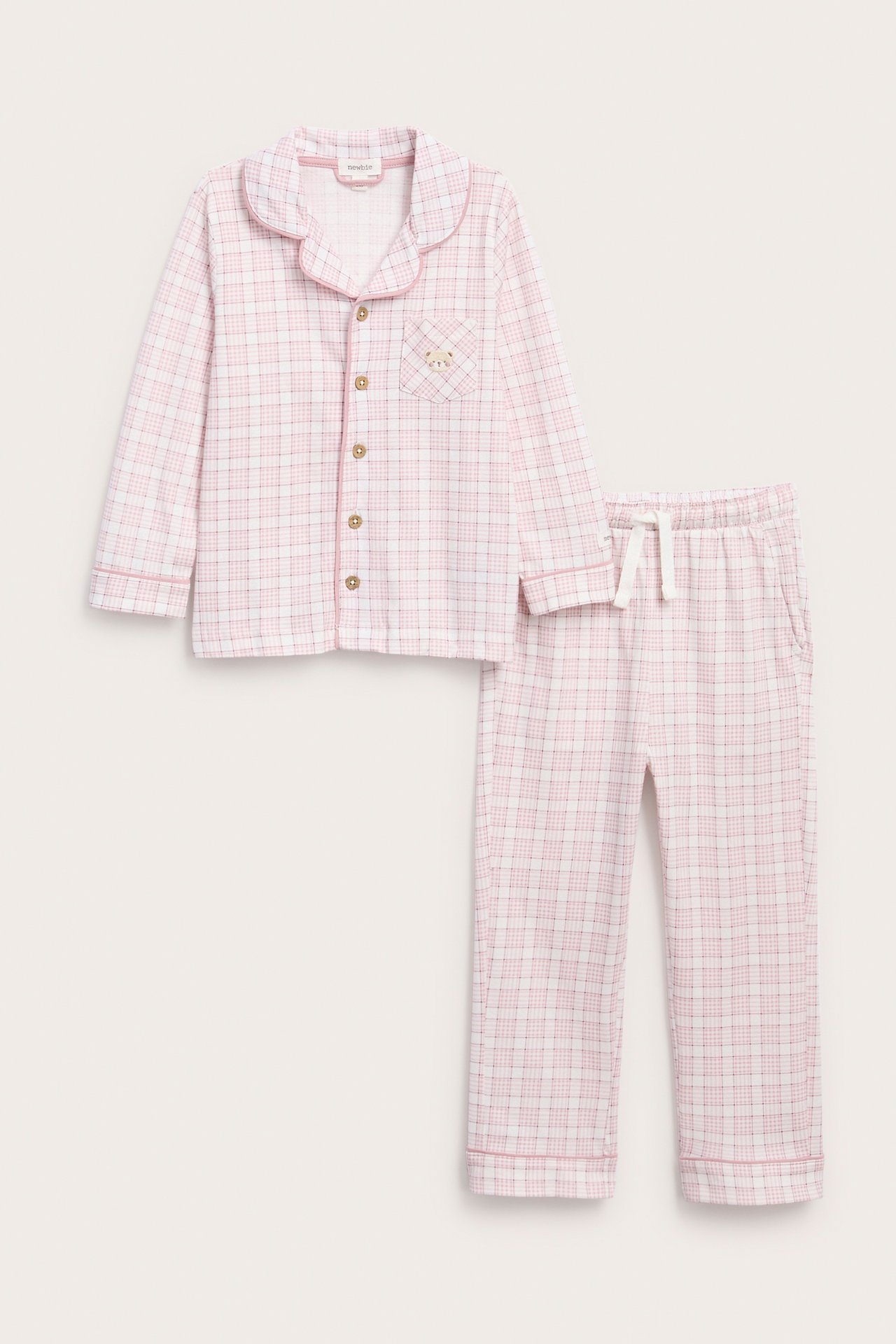 Front view of a kid's pink and white plaid pajama set with a button-up top and drawstring pants.