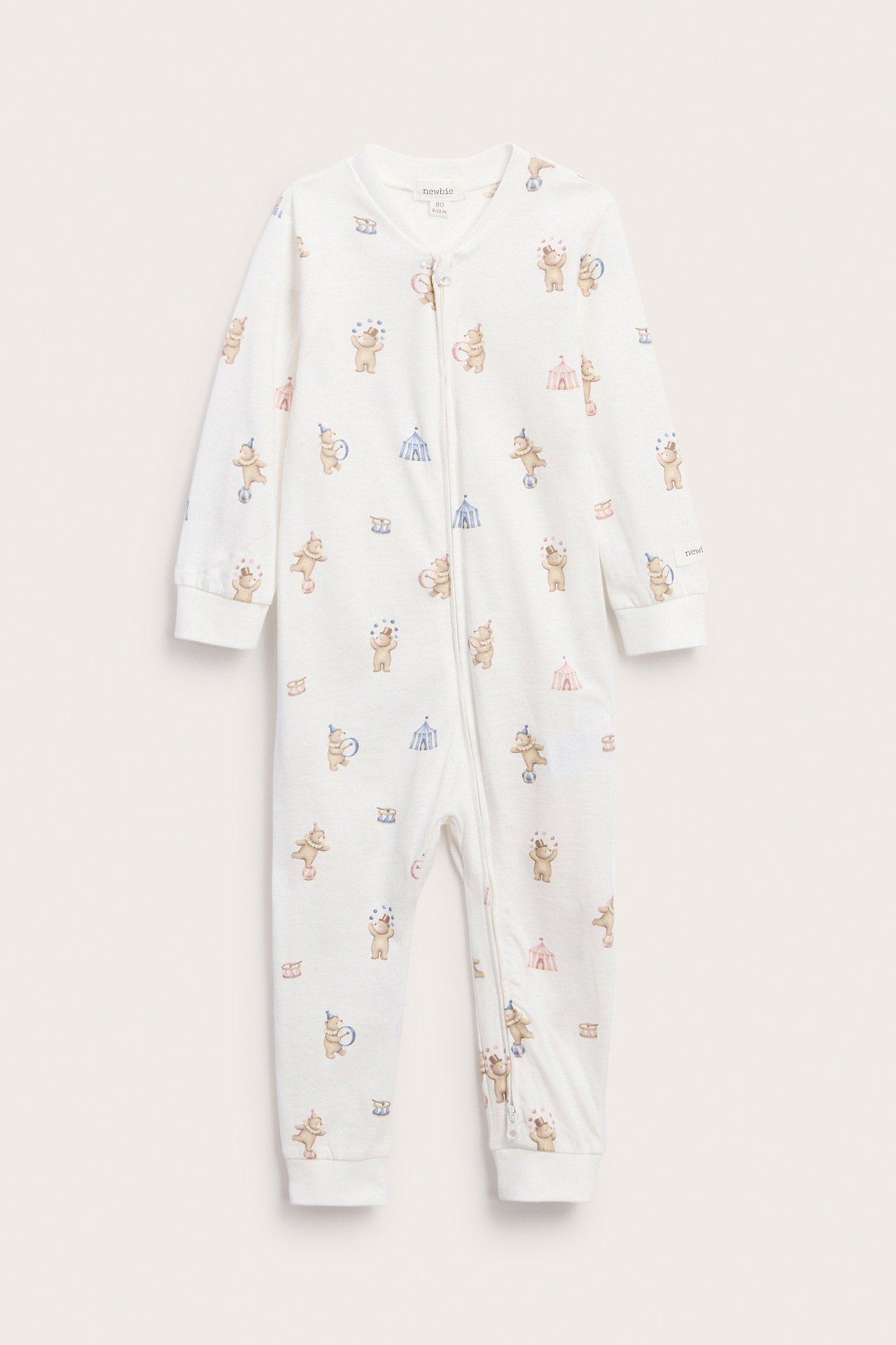 Front view of a baby's white one-piece pajama with a circus animal print and a zipper.
