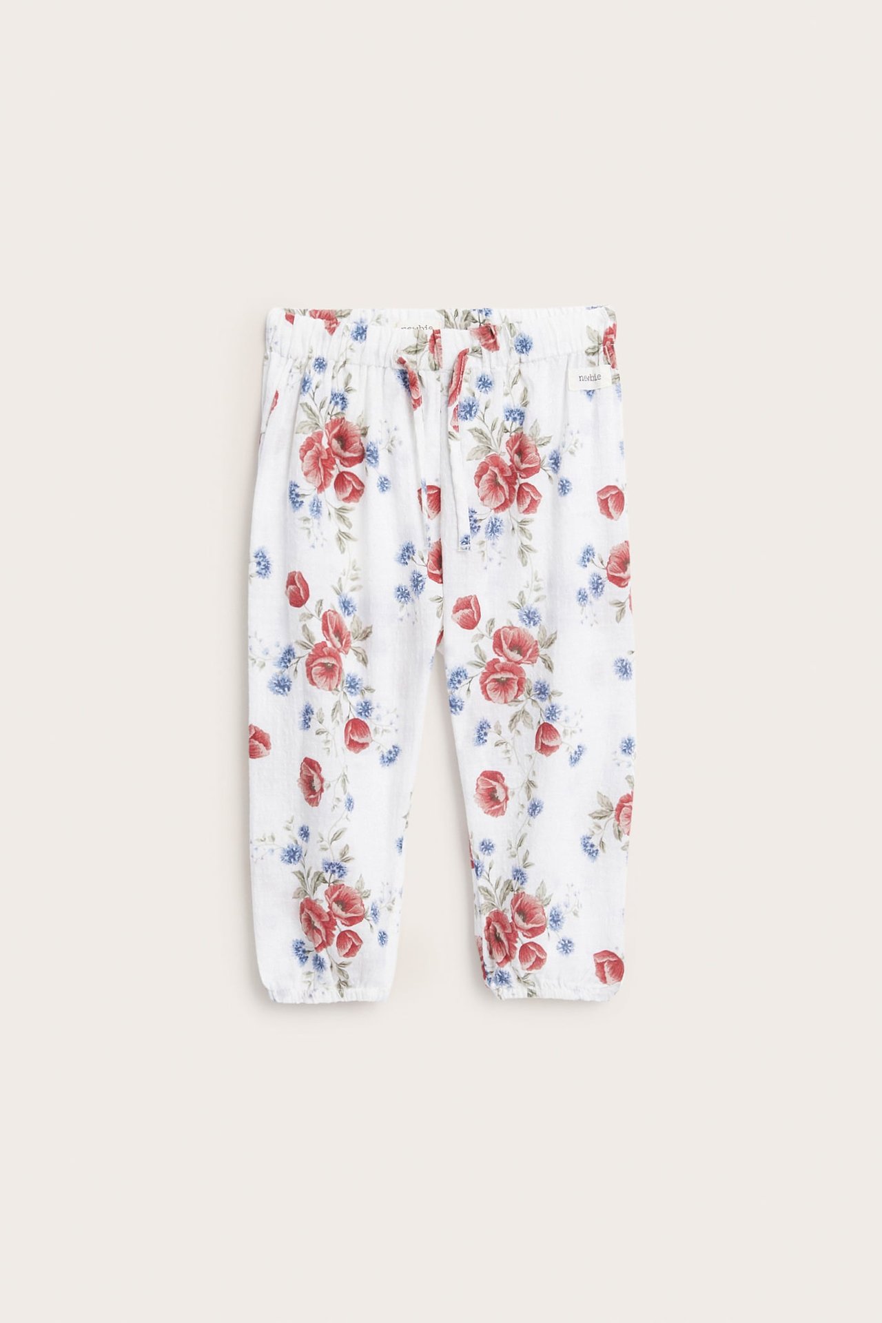 Vorderansicht von weißen Blumenhosen mit rotem und blauem Muster, Gummizug an Bund und Bündchen.