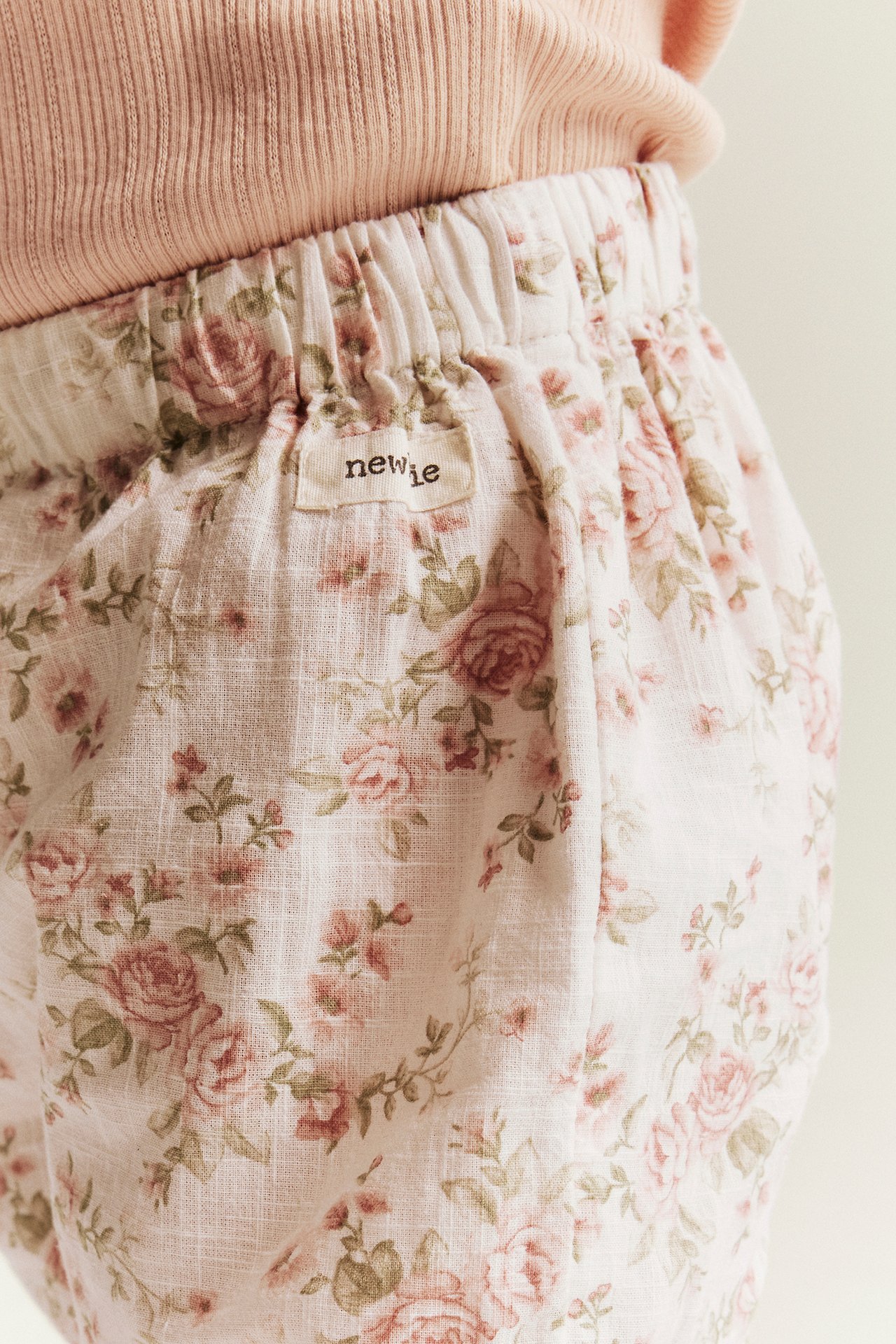 Nahaufnahme von rosa floralen Shorts mit Gummibund getragen mit einem rosa Rippentop.