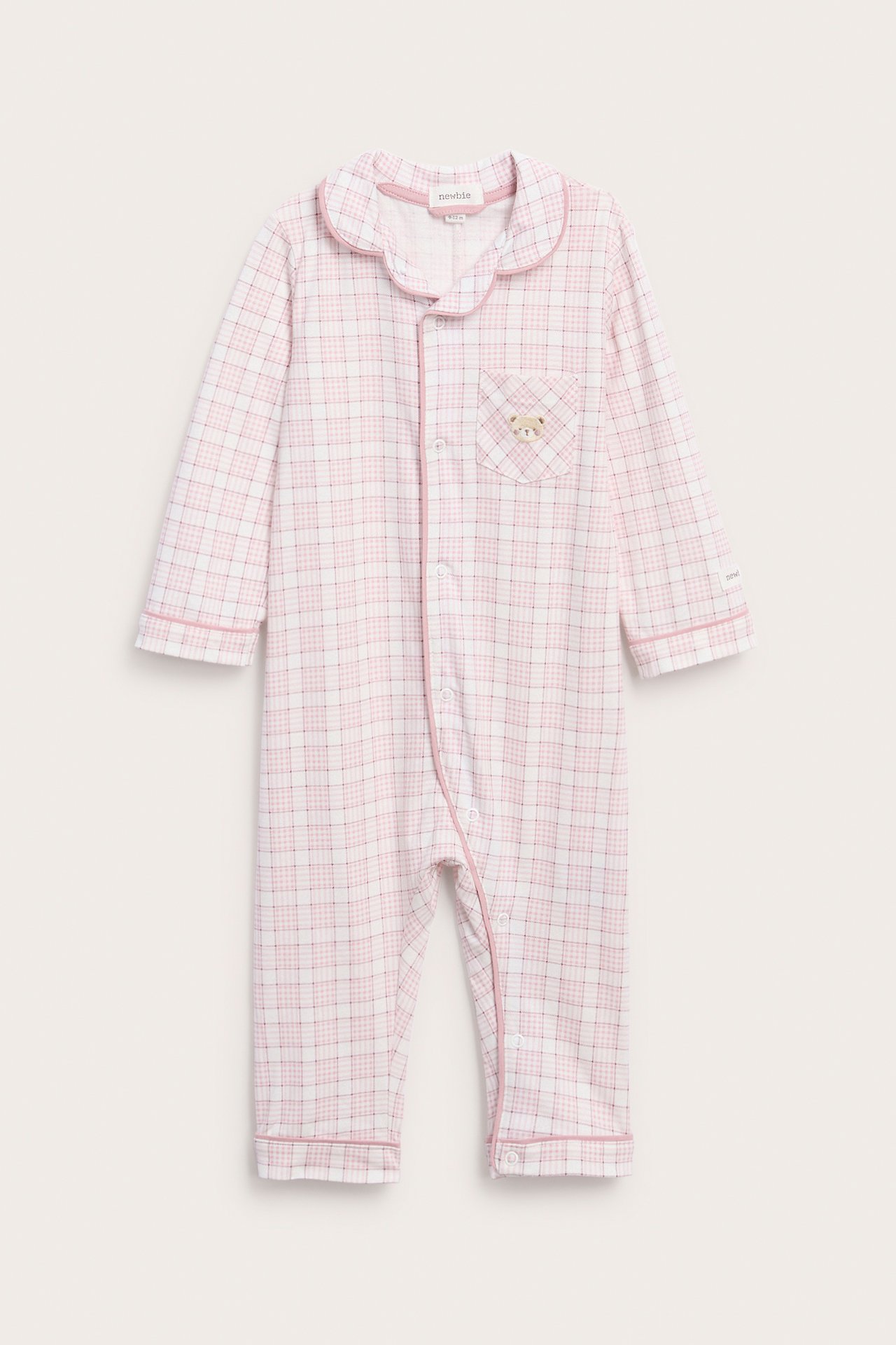 Front view of a baby's pink and white plaid long-sleeve romper with a collar and teddy bear patch.