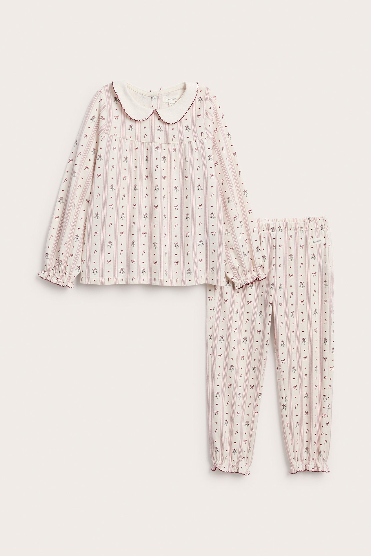 Front view: kid's cream pajama set with pink striped print, Peter Pan collar and ruffle cuffs.